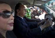 FILE - In this Friday Jan. 20, 2012 file photo. former dictator Jean-Claude "Baby Doc" Duvalier drives away from the courthouse with longtime companion Veronique Roy, after attending a closed hearing in Port-au-Prince, Haiti. A Haitian judge said Monday Jan. 30, 2012, that Duvalier should face trial for corruption, but not the more serious charges of human rights violations committed during his rule. Jean said the statute of limitations had run out on the human rights charges but not on the accusations of misappropriation of public funds. (AP Photo/Ramon Espinosa, File)